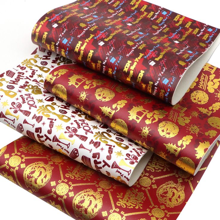 three rolls of red and gold wrapping paper on top of each other in different patterns