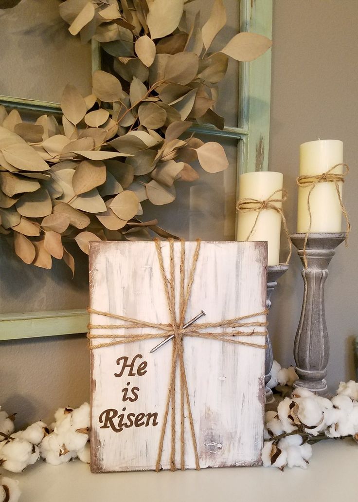 a wooden box with a message on it sitting next to cotton flowers and a candle