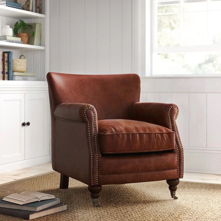 a brown leather chair sitting on top of a rug next to a book shelf filled with books