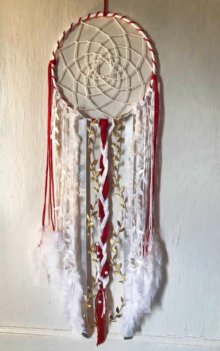 a red and white dream catcher hanging on the wall