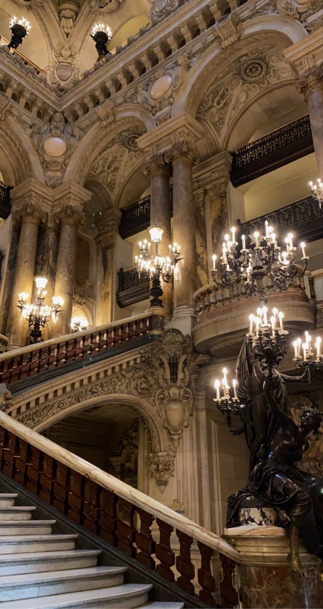 an ornate staircase with chandeliers and statues