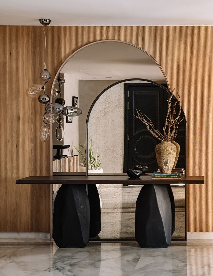 a table with two black vases on it and a mirror in the back ground