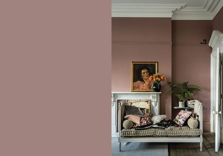 a living room filled with furniture and a painting on the wall next to a doorway