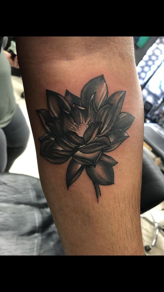 a black and white lotus tattoo on the leg