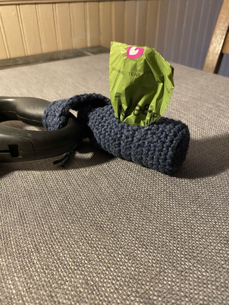 a pair of black shoes sitting on top of a bed next to a green bag