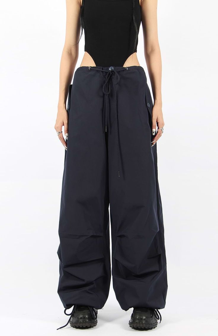 There’s a new trend in town, and it’s nightcity clothing’s Button Pocket Oversized Parachute Pants. These comfy, lightweight pants look great when paired with a crop top or graphic tee and sneakers. With a drawstring waistline, these pants are comfortable and secure, and the oversized fit gives them an effortless and chill look. Add these pants to your wardrobe, and you’ll never have a dull moment — you’ll always be ready for an impromptu night out, no matter how casual it might be.
Gender: Wome Wide Leg Cargo Style Parachute Pants For Loungewear, Baggy Chic Cargo Bottoms, Chic Wide Leg Parachute Pants For Streetwear, Chic Baggy Cargo Style Bottoms, Chic High Waist Parachute Pants For Streetwear, Urban Baggy High-waisted Pants, Urban Wide Leg Parachute Pants For Work, Chic Baggy Wide-leg Parachute Pants, Chic Baggy Parachute Pants