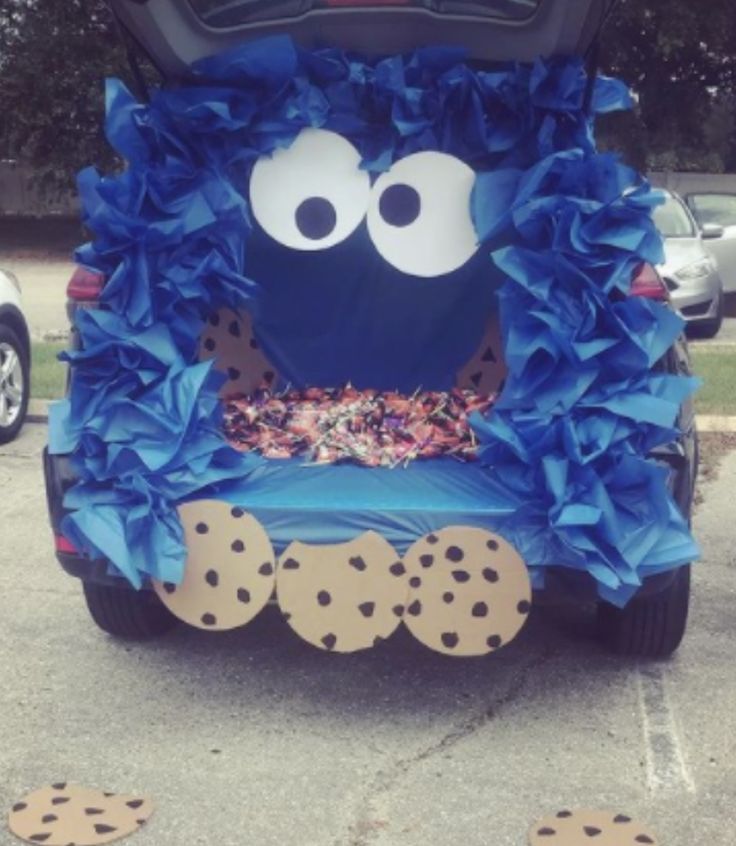 a car decorated with blue tissue paper and cookie cookies on the front seat is parked in a parking lot