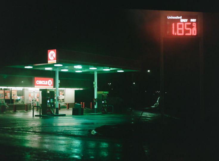 an empty gas station at night with the time displayed