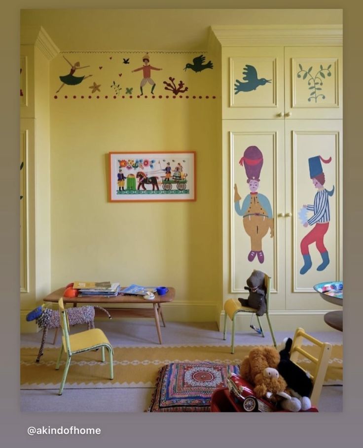 a child's room with yellow walls and pictures on the wall, including children's toys