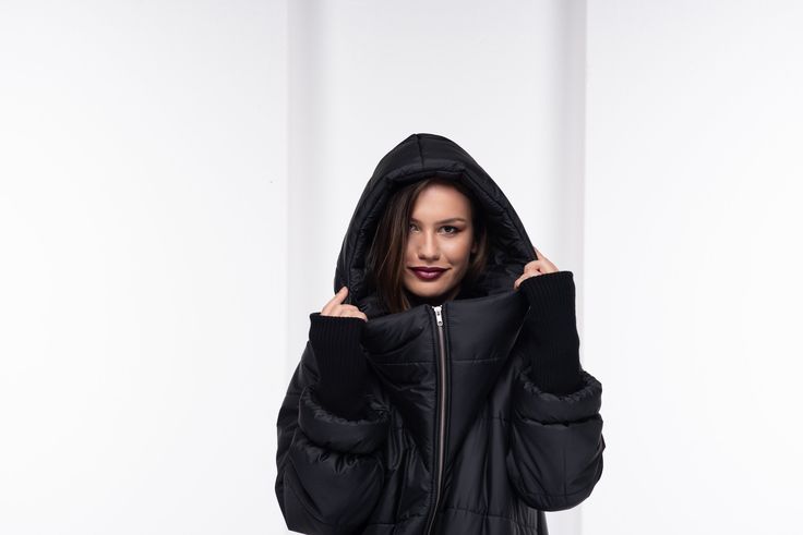 "This oversize winter jacket has elastic fabric on the sleeves. This is an extravagant model with a large hood, side pockets, long front zipper, and high collar when zipped. This urban-style jacket has a street vibe and will keep you warm for sure. * Please have in mind the model is oversize - for a fitted look please go a size down. Review from our customer: \"This coat is amazing! As soon as I put it on and stepped outside, I received so many compliments. Everyone said I looked so cozy...lol, My hubby thought it was way more expensive than I paid. Great quality, construction, and fast shipping!\" The model in the picture is 168cm. ⅼ 5.5 ft. tall and is wearing size S / Color: Black 🌟 INFO: * Worldwide EXPRESS shipping - please provide a phone number for shipping documents * US Sizing XS Steampunk Outfits Women, Oversized Hooded Coat, Black Cotton Jacket, Coat Waterproof, Black Quilted Jacket, Streetwear Jackets, Jacket Puffer, Loose Coat, Black Winter Coat