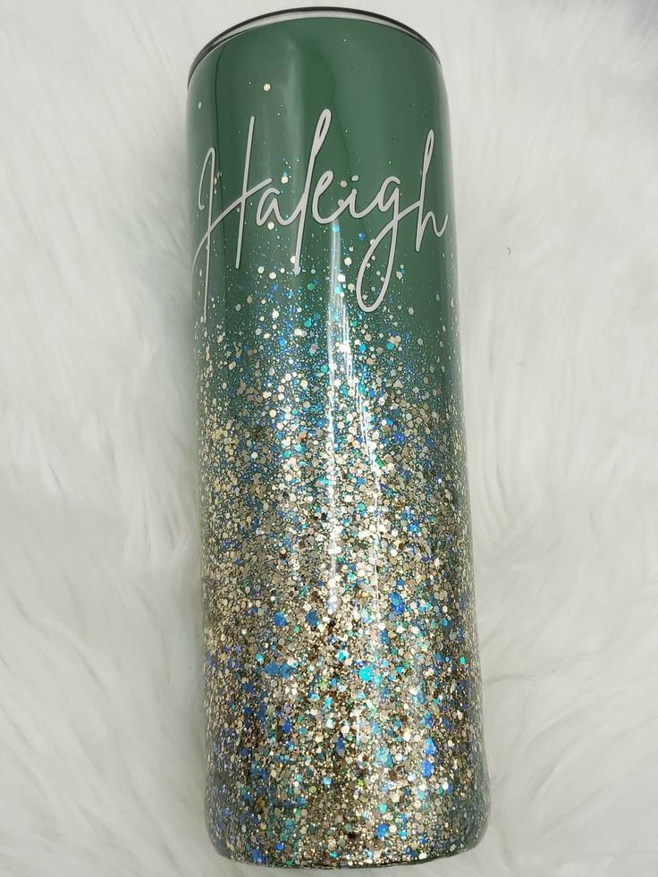 a green and gold glitter tumbler with the word haleigh on it