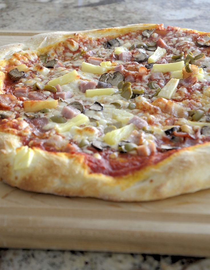 a pizza sitting on top of a wooden cutting board