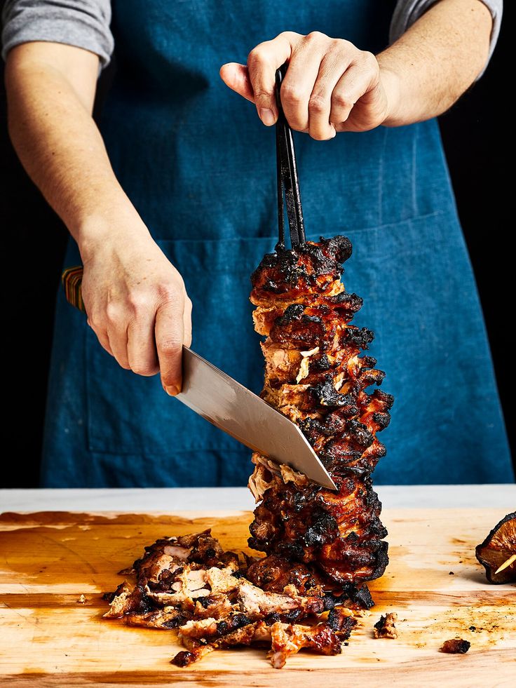 a person cutting meat with a large knife