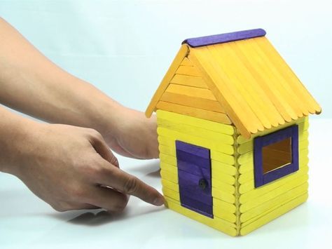 a person is touching the side of a toy house