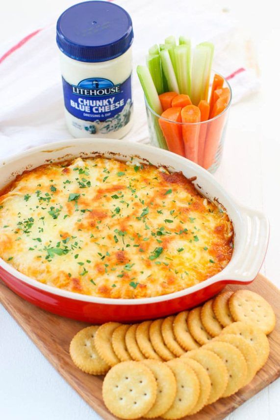 a casserole dish with crackers and carrots next to it