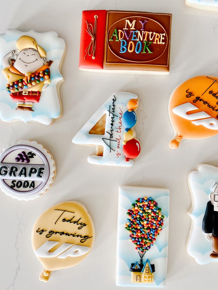 decorated cookies are arranged in the shape of numbers and characters for an adventure book themed birthday party