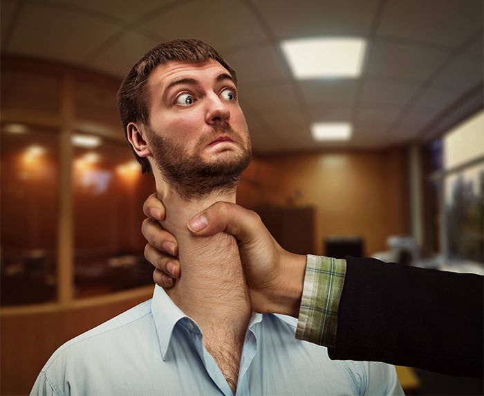 a man holding another mans neck in an office setting