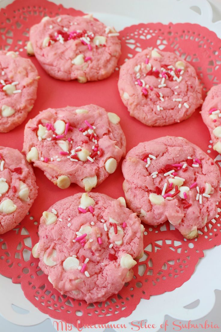 pink cookies with sprinkles and white chocolate chips on a red doily