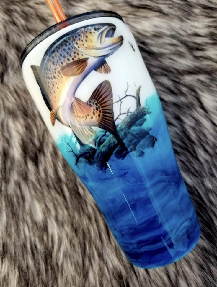 a fish painted on the side of a cup with straw sticking out of it's mouth