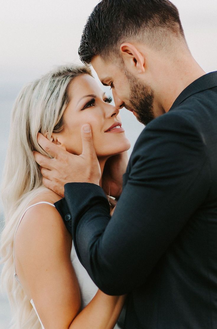 a man and woman embracing each other in front of the ocean