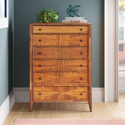 a wooden chest of drawers sitting on top of a hard wood floor