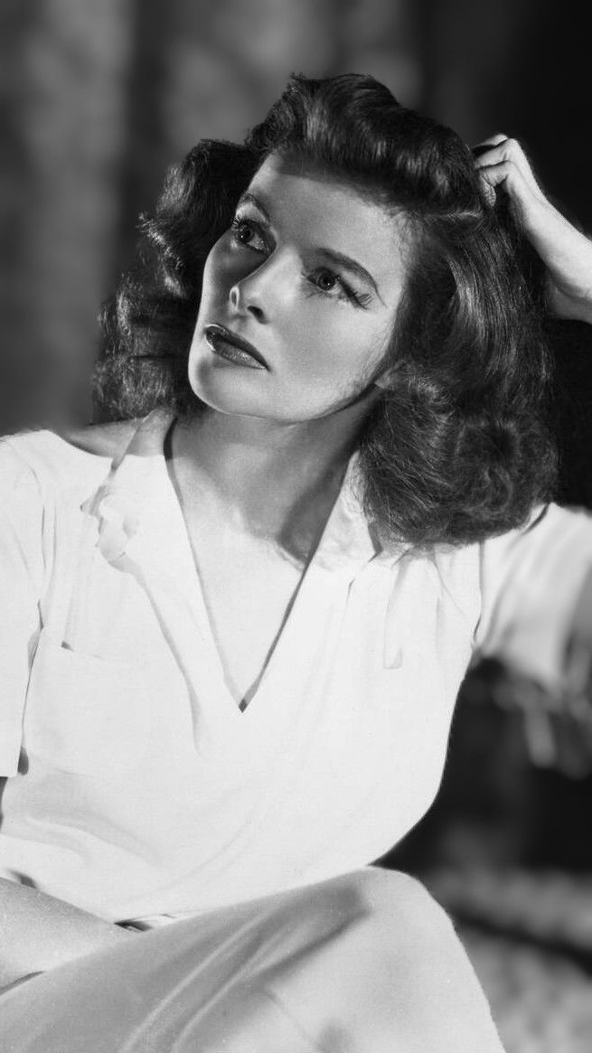 an old black and white photo of a woman with her hands on her head,