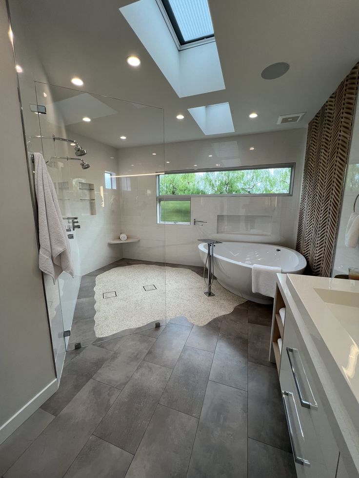 a large bathroom with a skylight above the bathtub