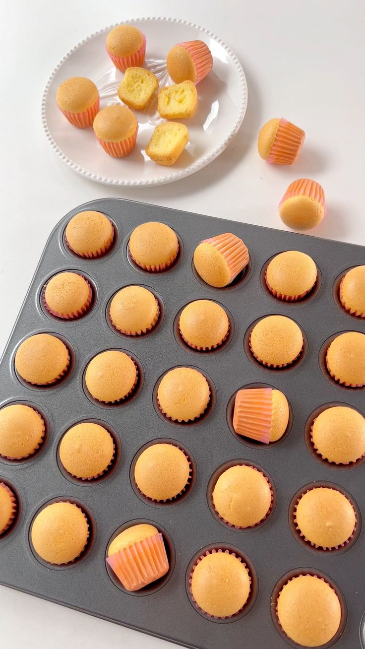 a muffin pan filled with cupcakes next to a plate of cut up cookies