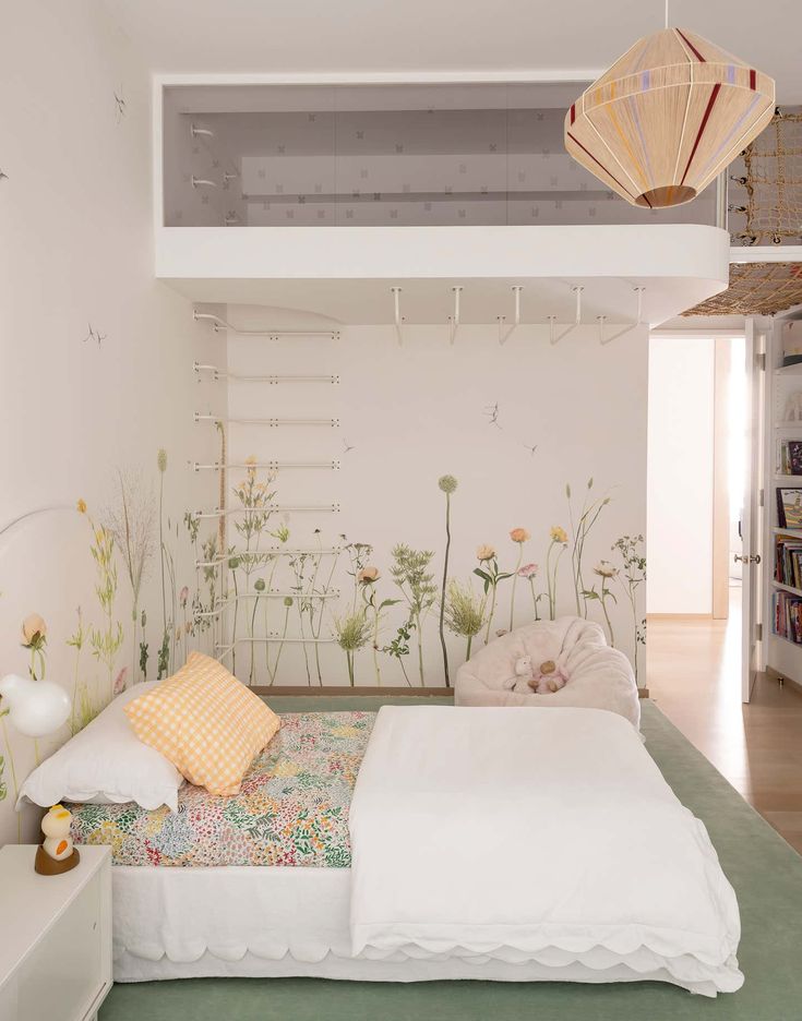 a bedroom with white walls and flowers painted on the wall behind the bed is a bookcase