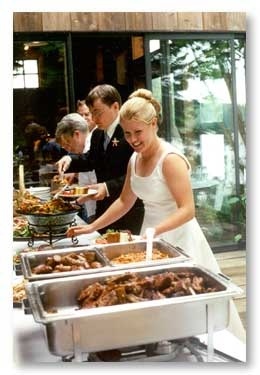 a woman in a white dress is serving food to people at a buffet line up