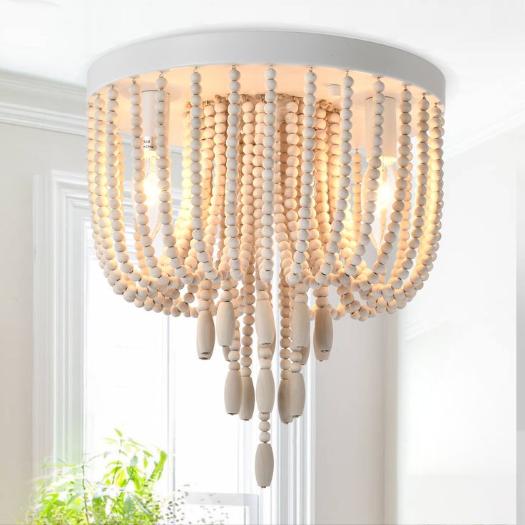 a white chandelier with beads hanging from it's ceiling in a living room