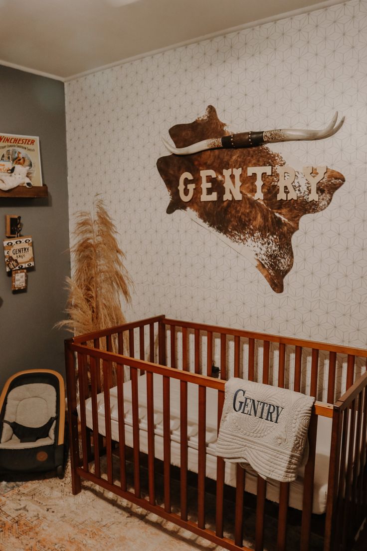 a baby's room with a wooden crib and deer head on the wall