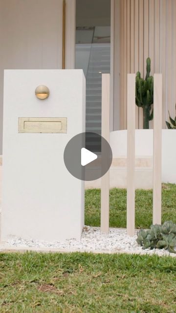 a white mailbox sitting on top of a lush green field next to a building