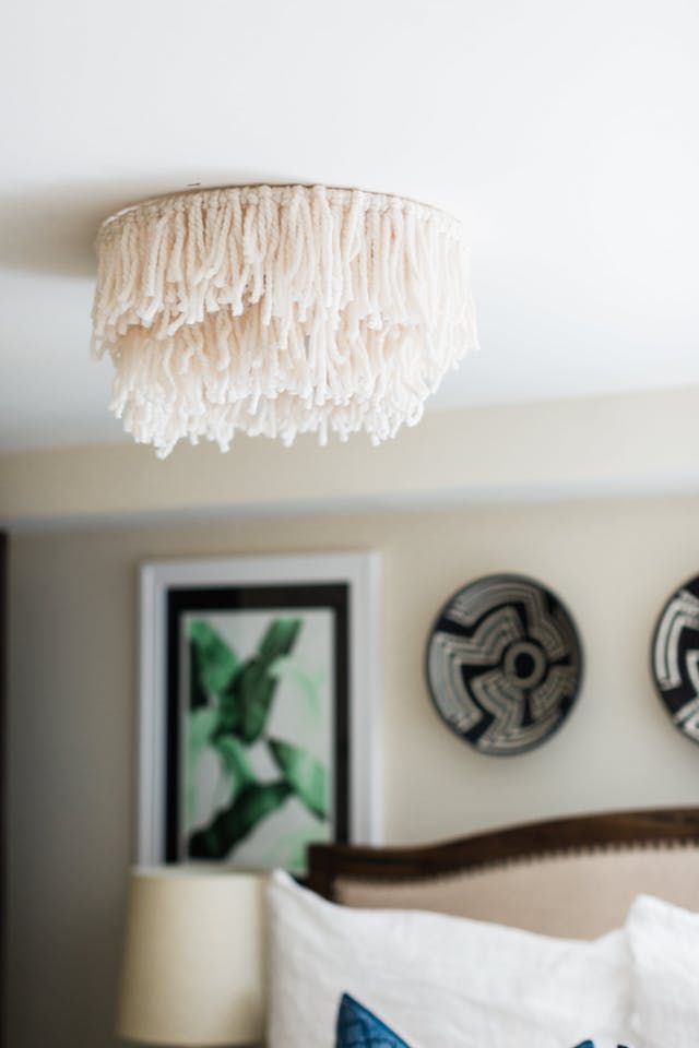 a bedroom with two pictures on the wall and a chandelier hanging from the ceiling