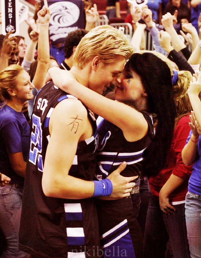 two people hugging each other in front of a crowd with confetti all around them