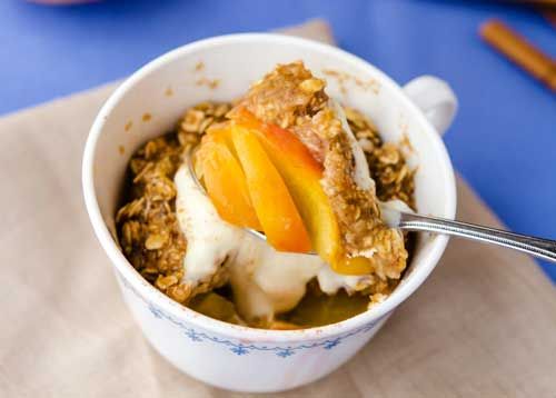 a bowl of oatmeal with peaches and yogurt on top