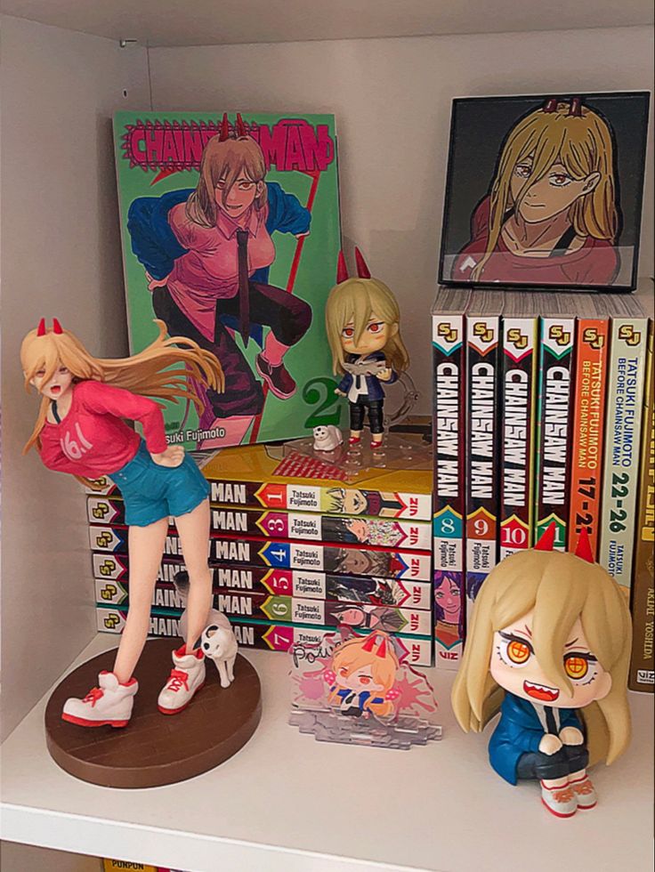 some anime figurines are on top of a book shelf next to other books