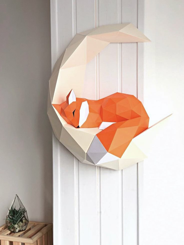 an origami fox hanging on the wall