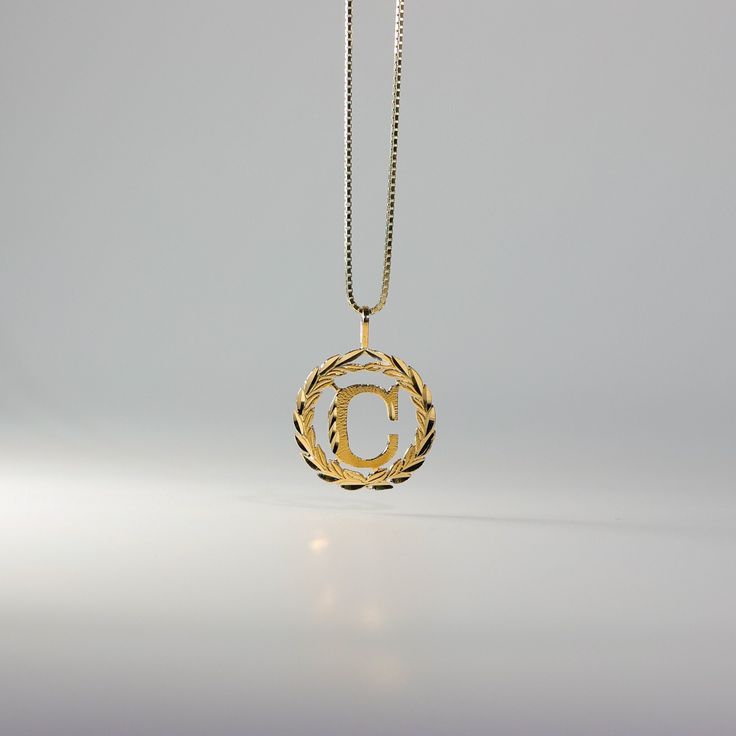 Level the way you wear a gold letter pendant. Stand out from the crowd and wear a solid gold letter pendant that outshines the typical lettering pendant. This 14K gold letter pendant redefines the way you wear a classic letter necklace. It presents the gold letter necklace in the most regal fashion, yet is still appropriate for wear on a day-to-day basis. Fall in love with how masterful this gold lettering pendant was created. It features intricate details that are nothing but stunning. The circ C Initial Necklace, Regal Fashion, Gold Letter Pendants, C Initial, Initial Wreath, Gold Initial Pendant, Gold Wreath, Beautiful Lettering, Gold Letter Necklace