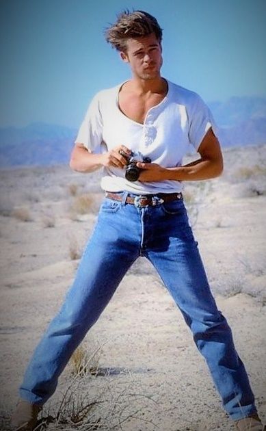 a man standing in the desert with his hands on his hips holding a baseball bat