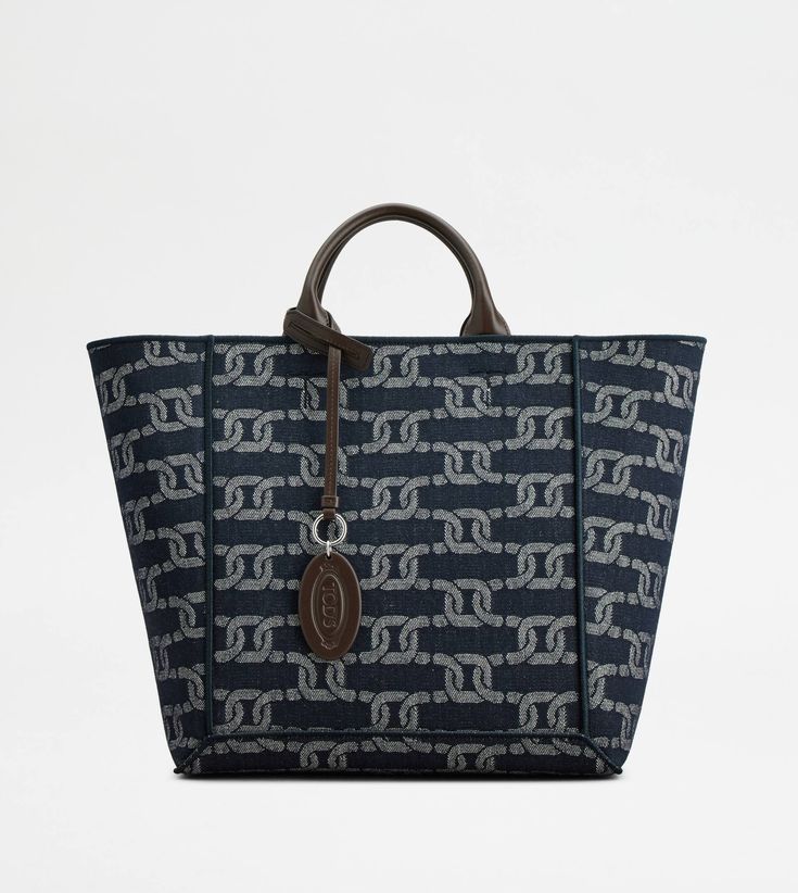 Shopping bag in denim with jacquard chain pattern and calfskin leather. Featuring two tubular handles, secured with maxi T-stitching, it comes with two long flat handles, for a versatile use. Enriched by the oval pendant with stamped Tod's logo, it is complemented by a removable internal pouch. Shopping In Italy, Printed Canvas Tote Bag, Chain Pattern, Double Up, Gift Boutique, Oval Pendant, Zip Pouch, Canvas Tote Bag, Blue Bags