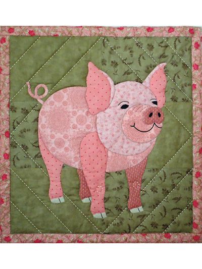 a pink pig is on a green quilt