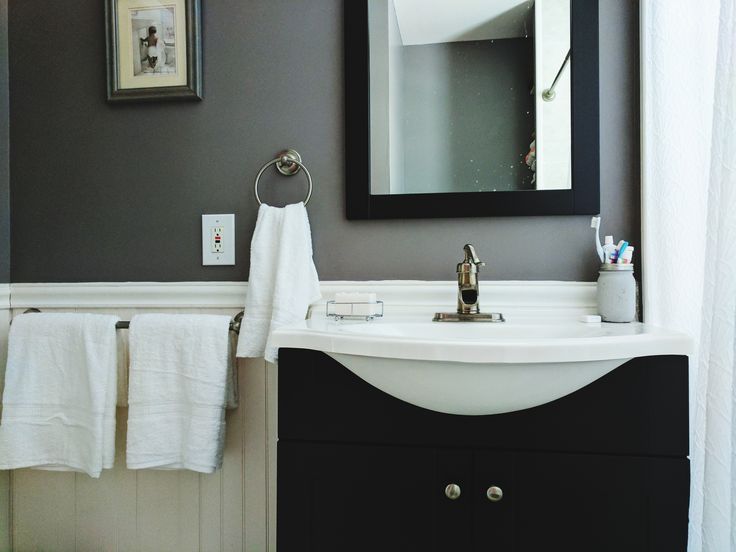 a white sink sitting under a bathroom mirror