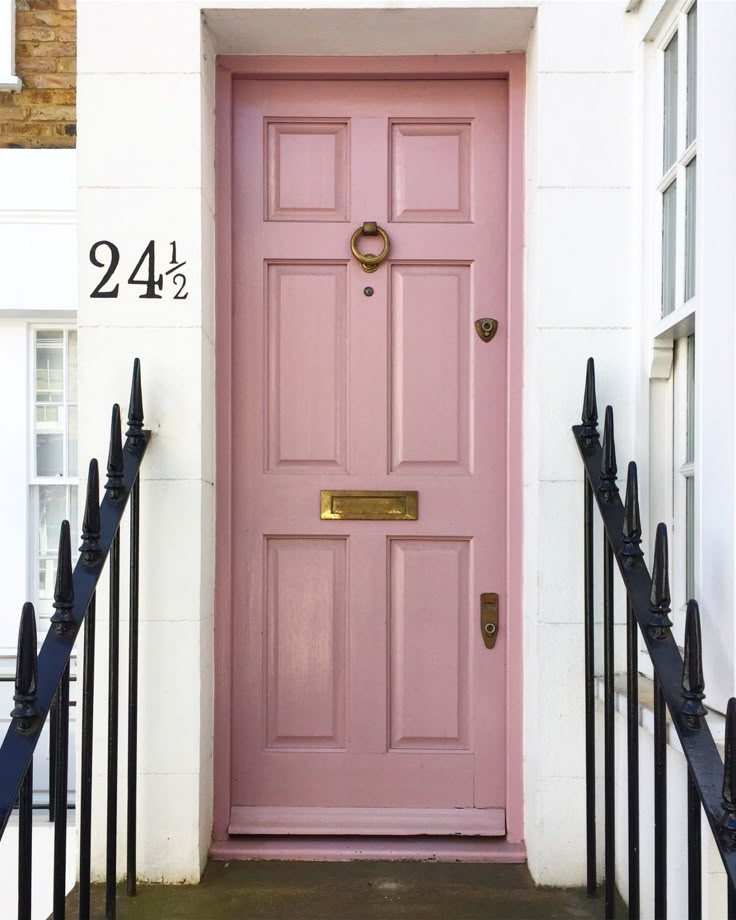 a pink front door on a white house