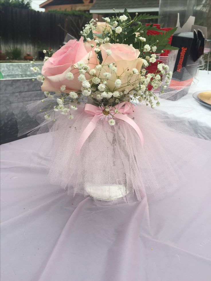 a vase filled with pink roses and baby's breath on top of a table