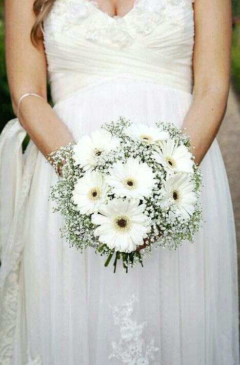 a bride holding a bouquet of white flowers