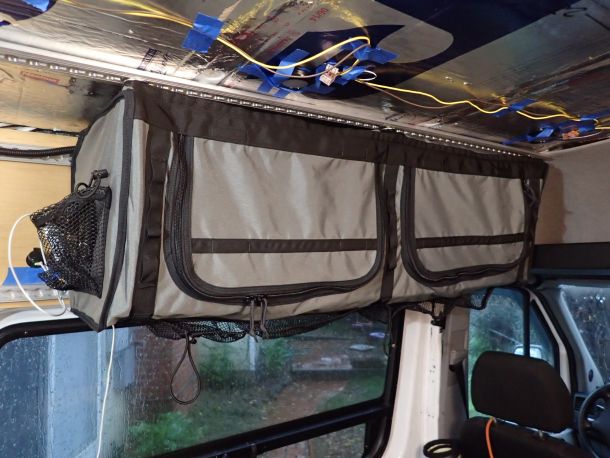 the back end of a vehicle with luggage hanging from it's ceiling and windows