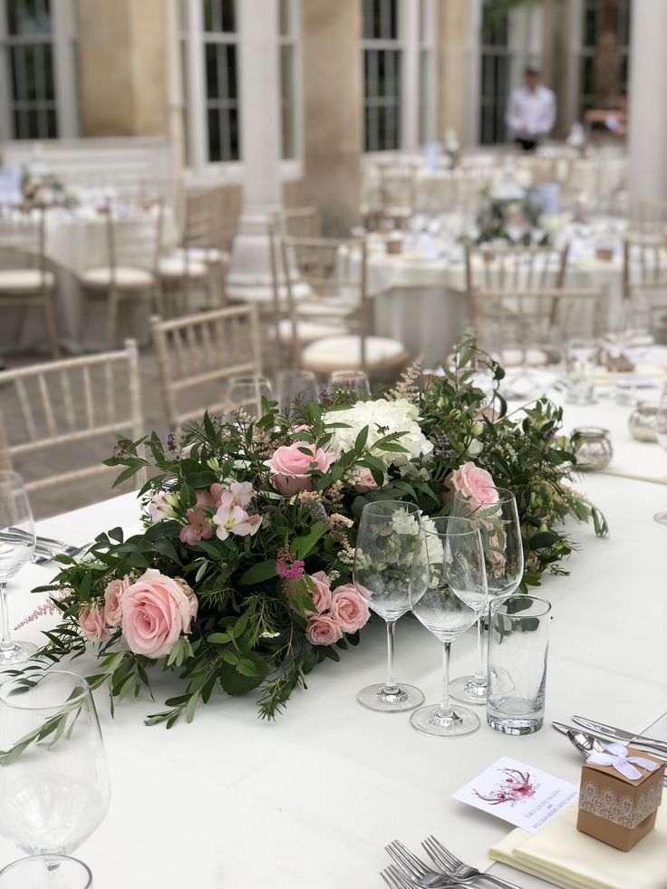 the table is set up with flowers and wine glasses for an elegant wedding reception or special event