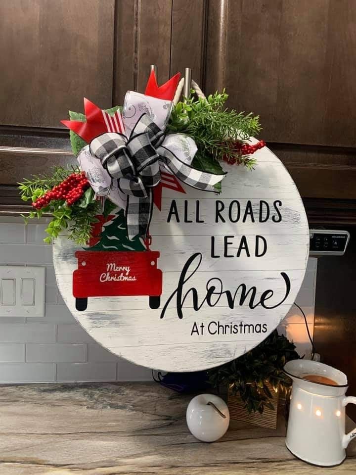 a sign that says all roads lead home at christmas with decorations on the front and side