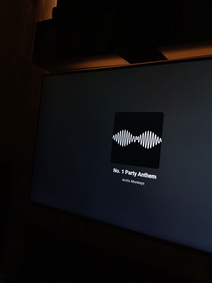 a flat screen tv sitting on top of a wooden table in front of a wall